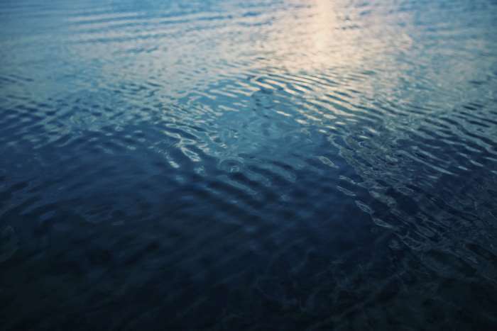 Blue water surface with ripples and reflections