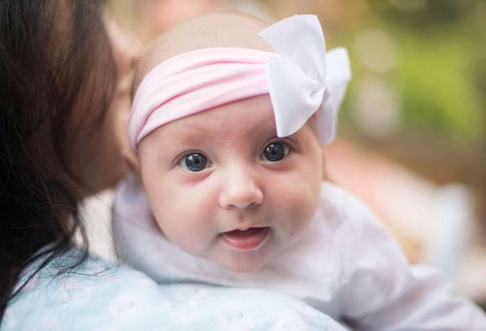 Baby with pink headband and white bow