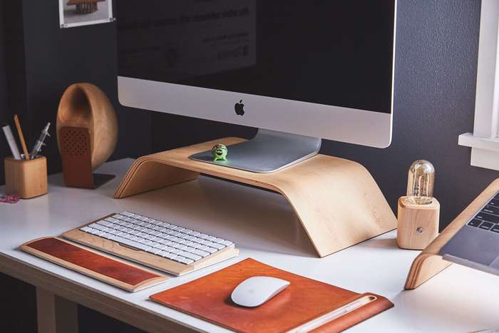 Modern Mac desk setup with wooden accessories