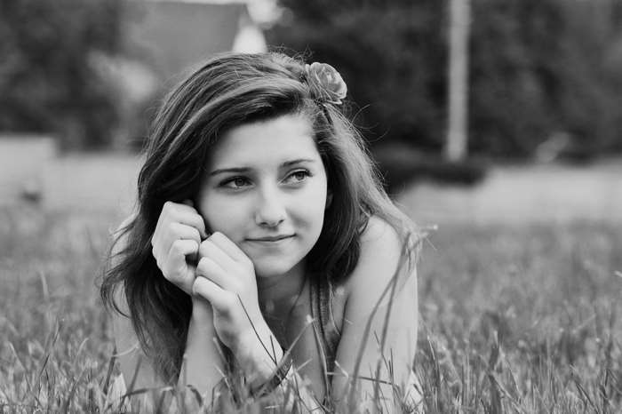 Black and white portrait of a young woman in a field