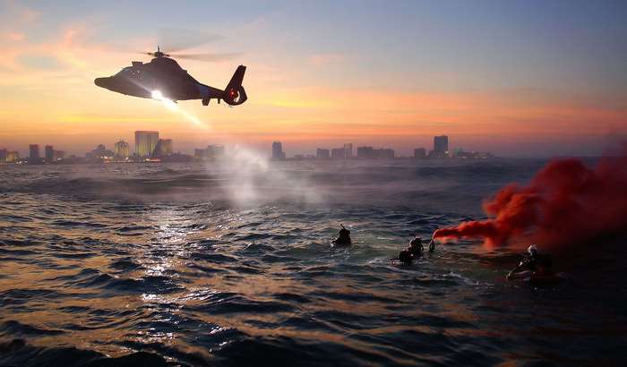 Coast Guard helicopter rescue training at sunset