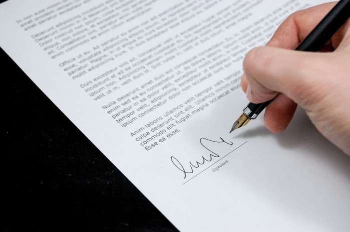 Hand signing a document with a fountain pen