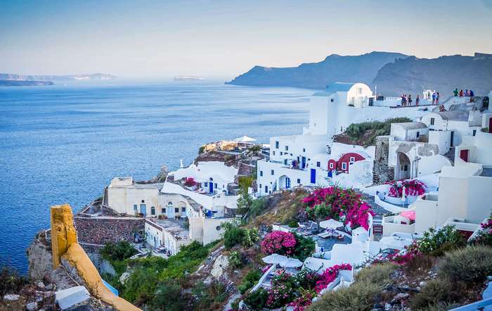 White buildings on a cliff overlooking the Aegean Sea in Santorini, Greece