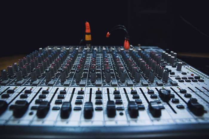 Audio mixing console with faders and knobs
