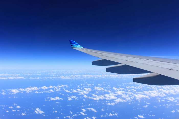Airplane wing flying over clouds