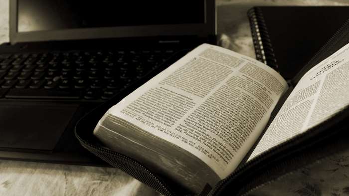 Open Bible next to Laptop and Notebook 4K