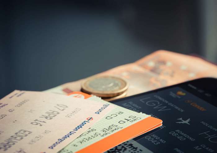 Boarding pass and euro coins on table