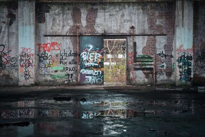 Graffiti-covered abandoned factory building with reflections