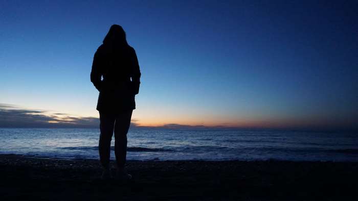 Silhouette of a person on a beach at sunrise