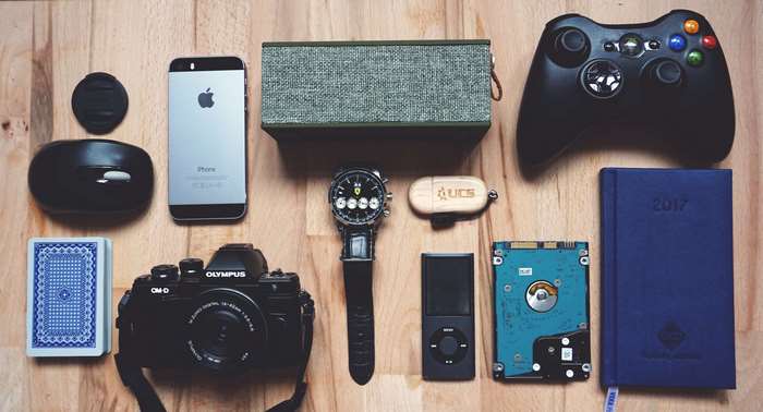 Collection of electronic gadgets and accessories on a wooden surface