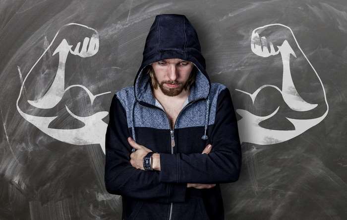 Man with drawn muscles on chalkboard