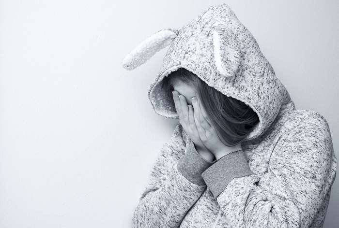 Teenage girl in bunny hoodie crying