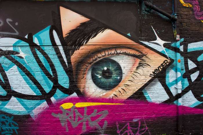 Graffiti mural of an eye on a brick wall