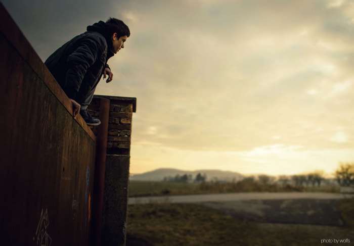 Boy on a ledge overlooking landscape