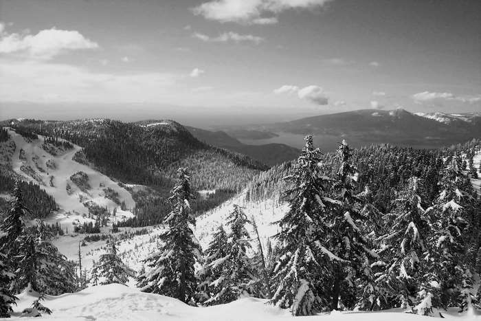 Snowy mountain landscape with evergreen trees and lake