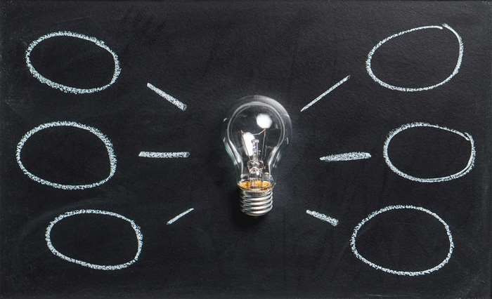 Light bulb with chalk circles on a blackboard