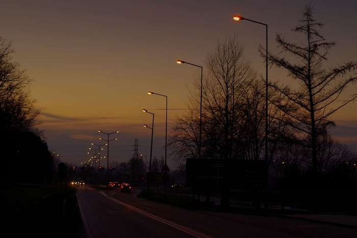 Evening Street with Lit Lamp Posts and Cars 4K