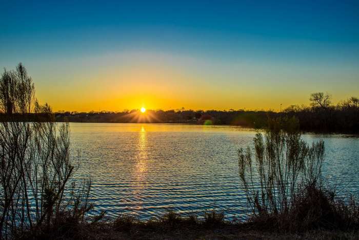 Sunset over a calm lake with trees
