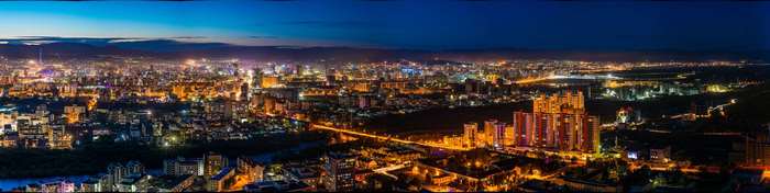 Panoramic night view of a city with illuminated buildings