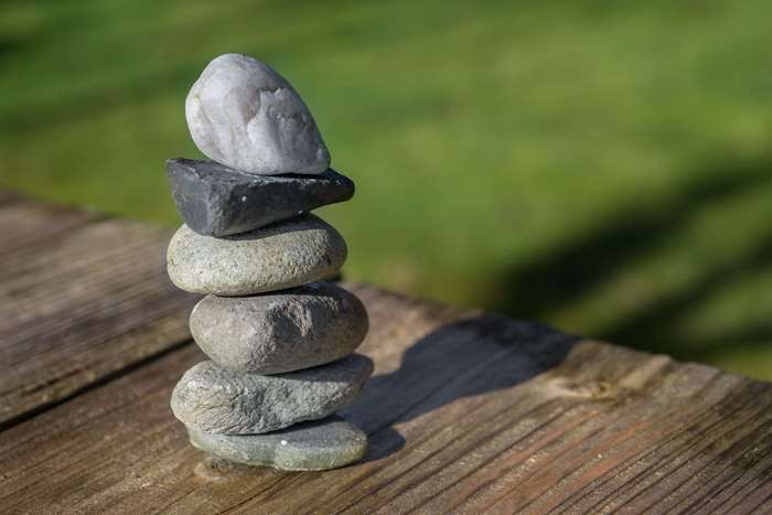 Stack of balanced stones on wooden surface