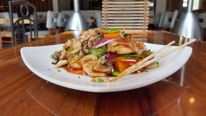 Oriental food on a white plate with chopsticks