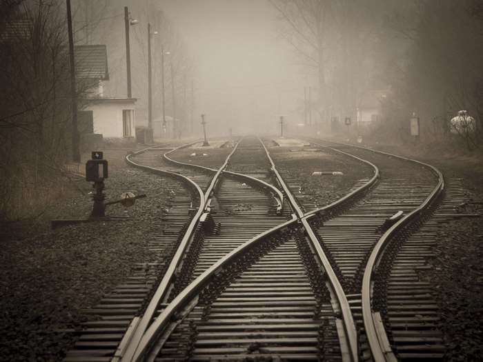 Train tracks diverging in foggy weather