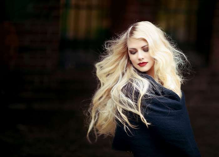 Beautiful blonde woman with red lipstick and dark shawl