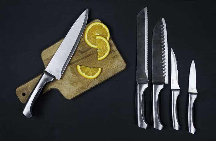 Knife set with orange slices on cutting board 4K