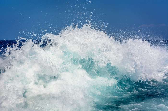 Ocean wave splashing with blue sky