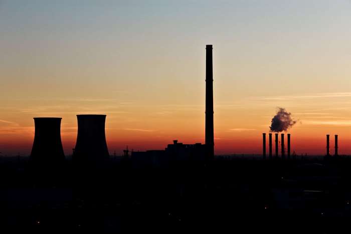 Industrial silhouette at sunset with smoke stacks