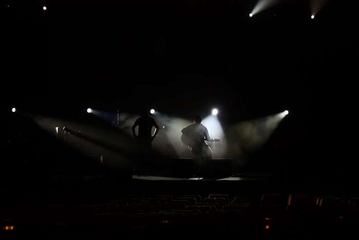 Band performing on stage with spotlights