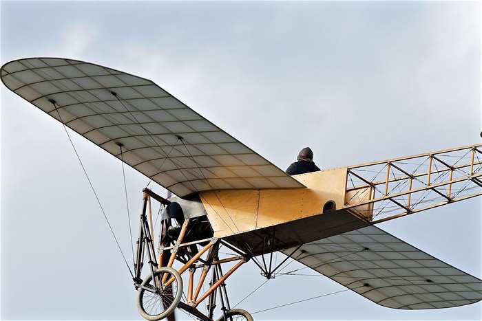 Antique biplane with pilot in the sky