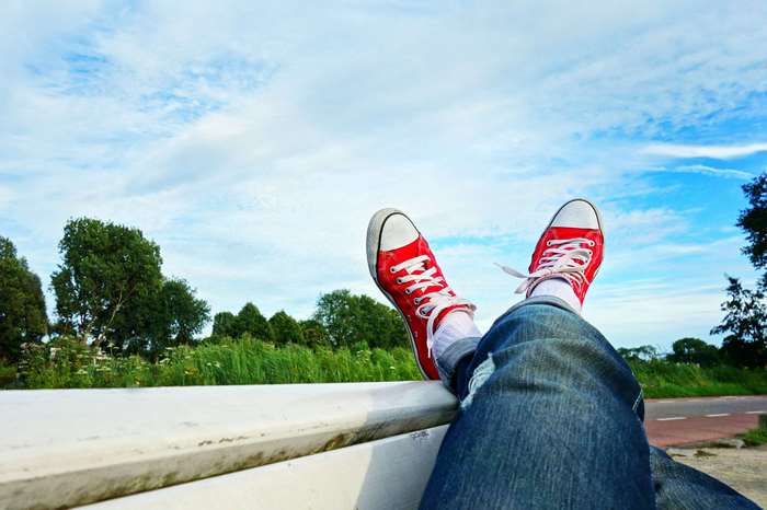 Person in red sneakers relaxing outdoors