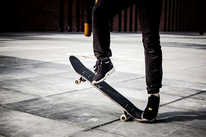 Person performing a skateboard trick on a tiled surface
