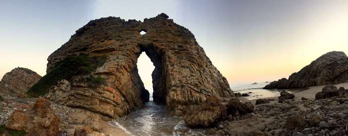 Rock Archway on a Rocky Beach at Sunset