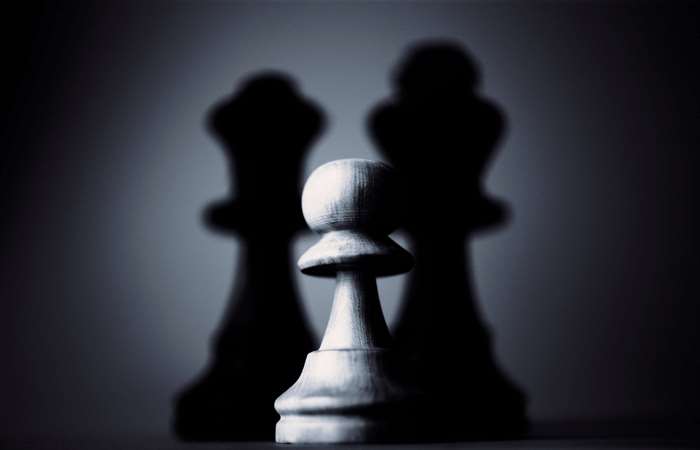 Chess pawn with king shadows in dark lighting 4K