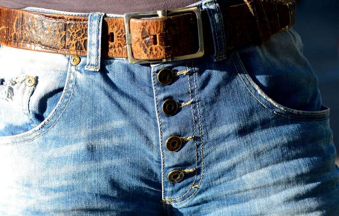 Close up of denim jeans with a leather belt