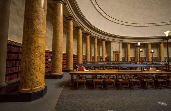 Interior of a grand library with marble columns and bookshelves