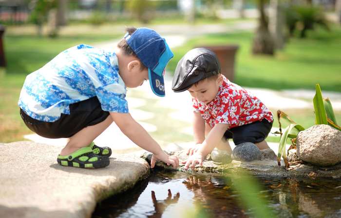 Two young boys playing by the water