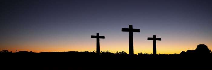 Three crosses silhouetted against a sunset sky