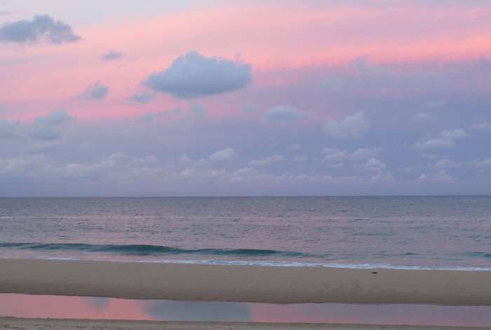 Pink sky over the ocean and beach at sunset