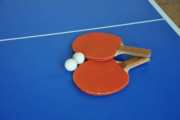Table tennis rackets and balls on a blue table