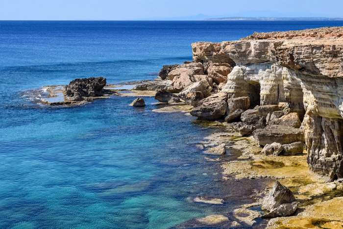 Rocky coastline with sea caves and turquoise ocean