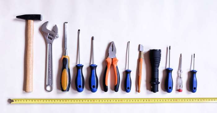 Assortment of tools including hammer, wrench, screwdrivers, pliers, and tape measure