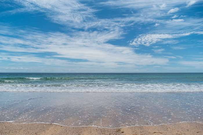 Beach with ocean waves and blue sky 4K