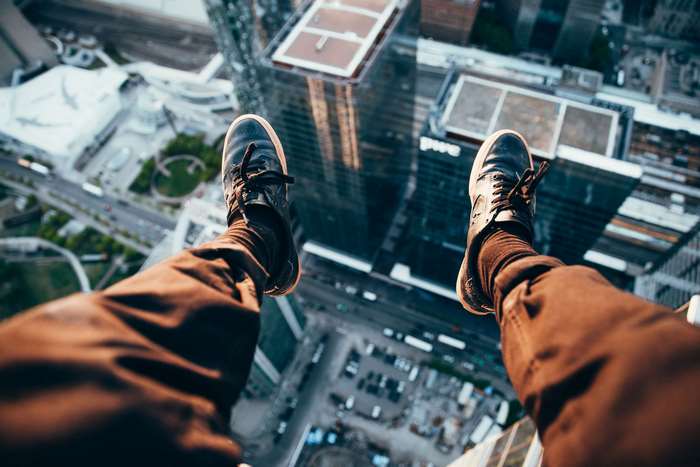 Person sitting on a rooftop overlooking city buildings
