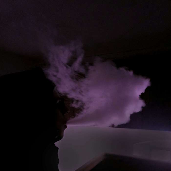 Person vaping purple smoke