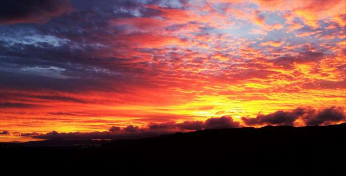 Dramatic sunset sky with silhouette of land