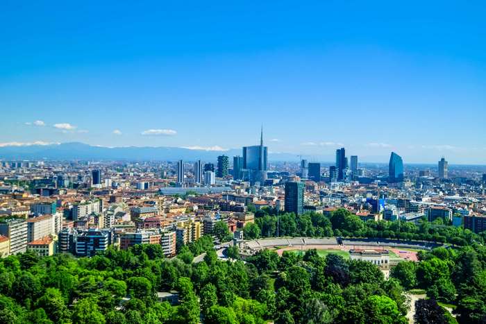Panoramic cityscape of Milan with skyscrapers and mountains