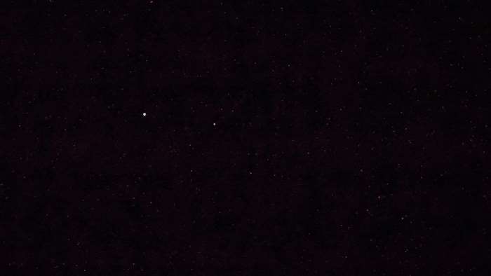 Night sky with stars and two bright celestial bodies